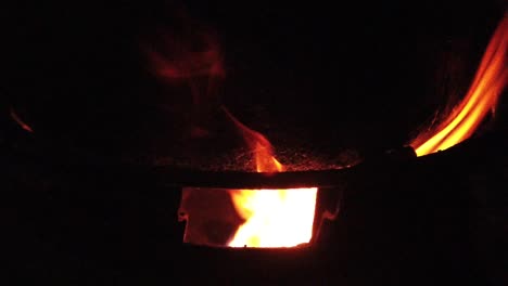 slow motion burning wood logs on fire in a barrel at night