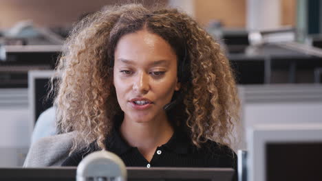 mujer de negocios con auriculares telefónicos hablando con la persona que llama en el departamento de servicios al cliente