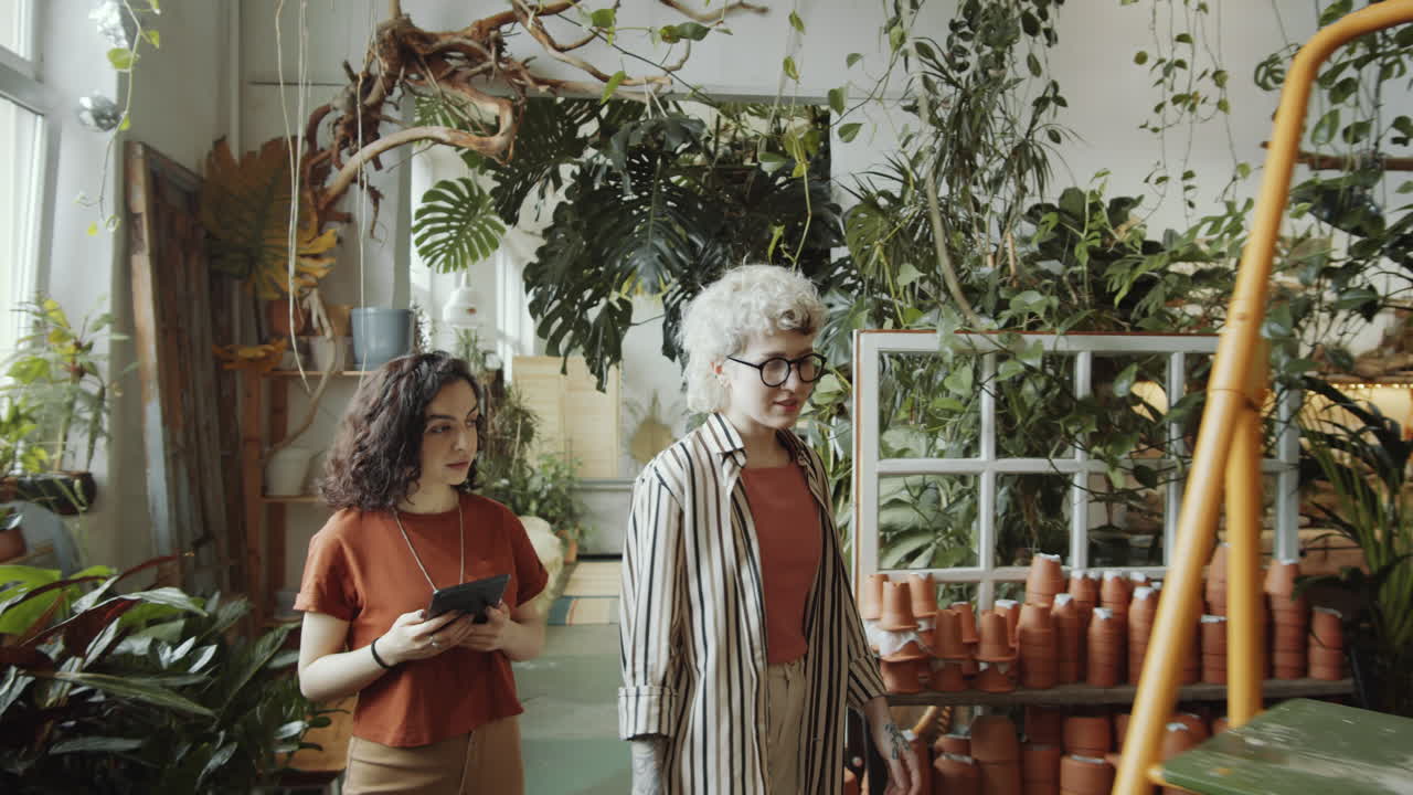 floristas caminando con una tableta en una tienda de flores