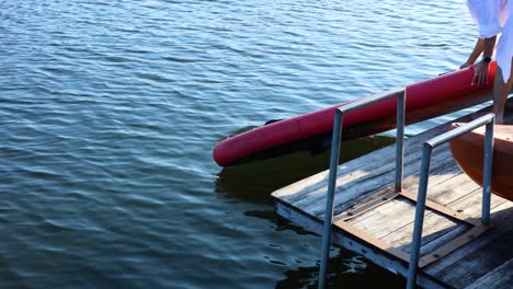 person launching a paddle board into water