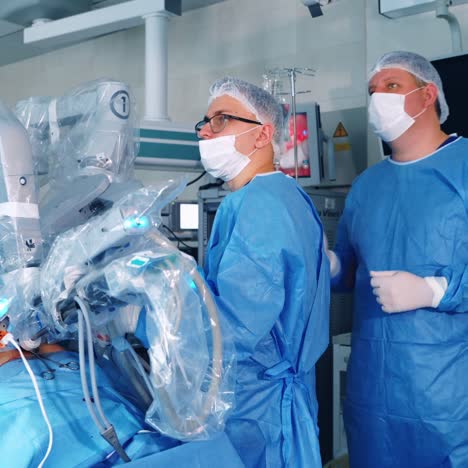 contemporary medical device in a surgical room. doctors in medical uniform look at the monitor during robotic surgery. da vinci system.