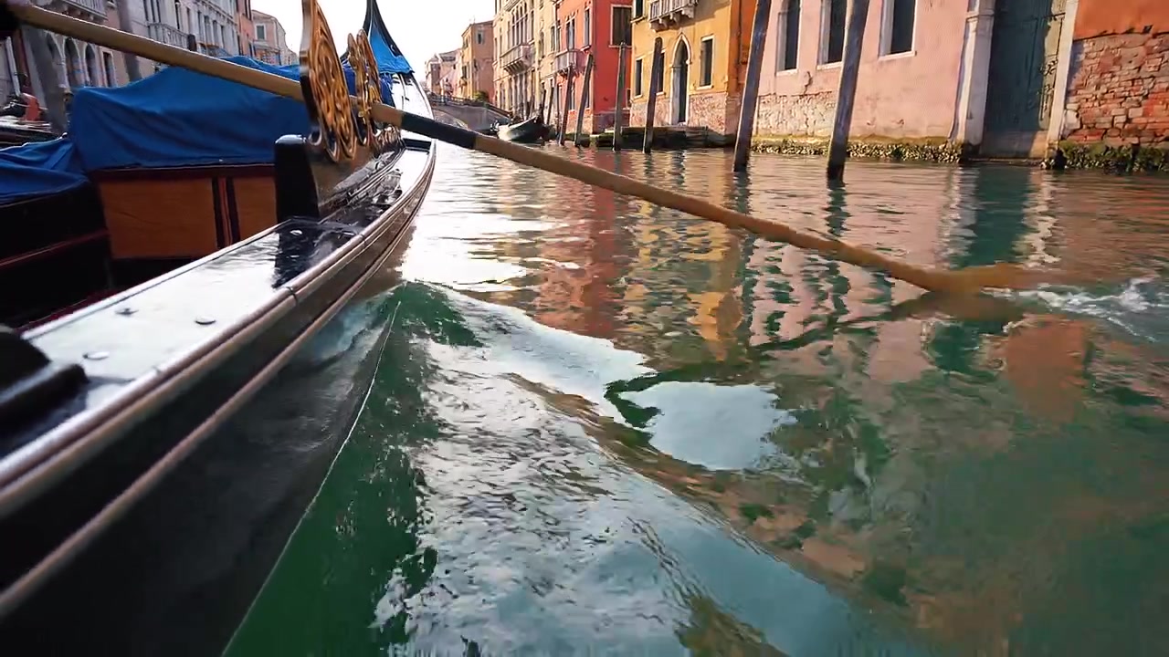 Vista detallada de una góndola remando por agua clara de canal