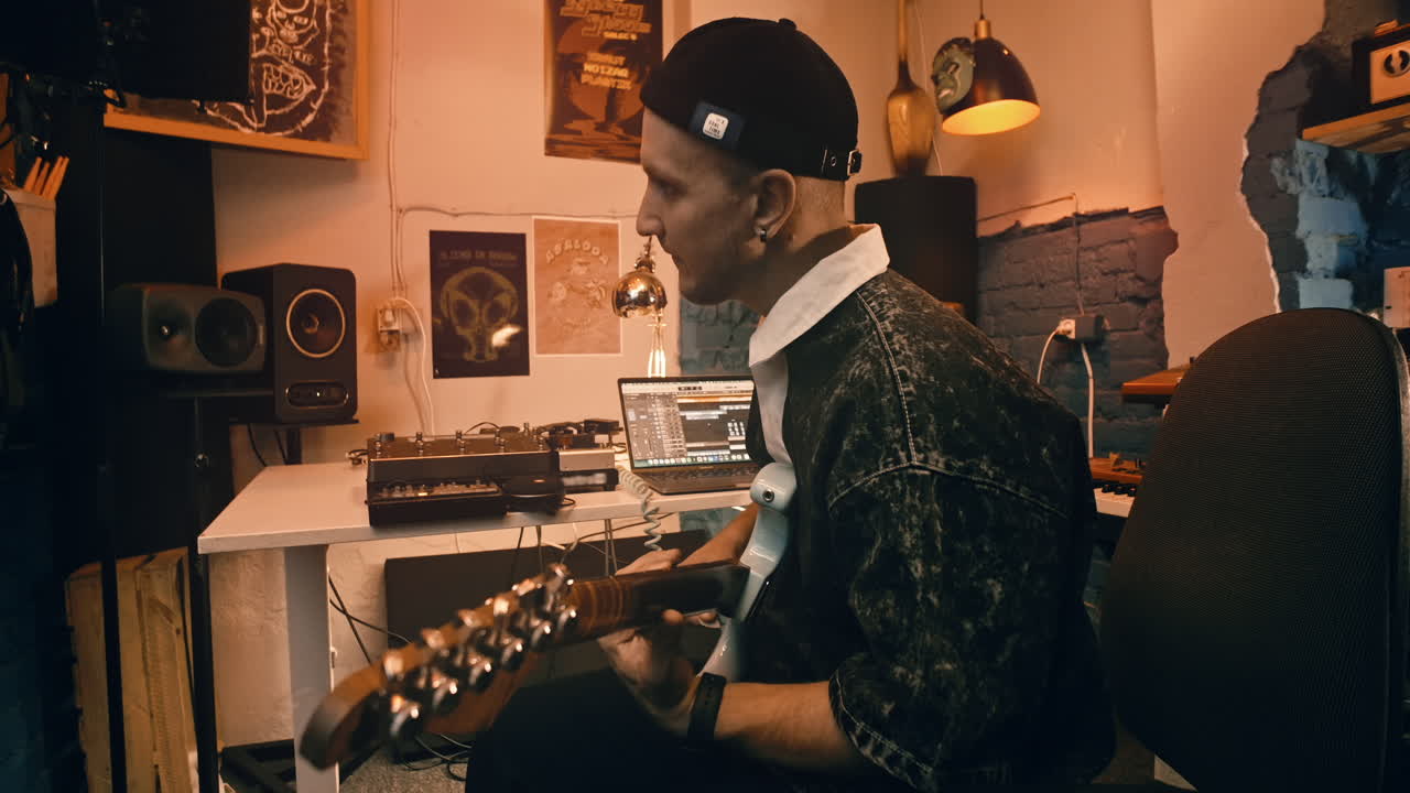Musician playing guitar in a home studio