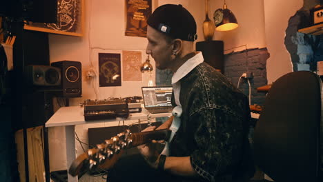musician playing guitar in a home studio