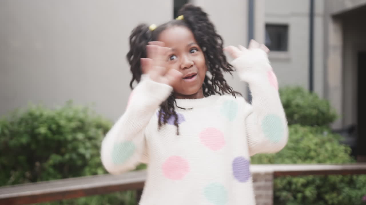 Outdoors, girl wearing colorful sweater with excited and surprised expression
