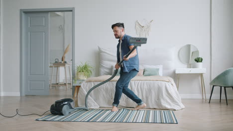 man vacuuming a bedroom