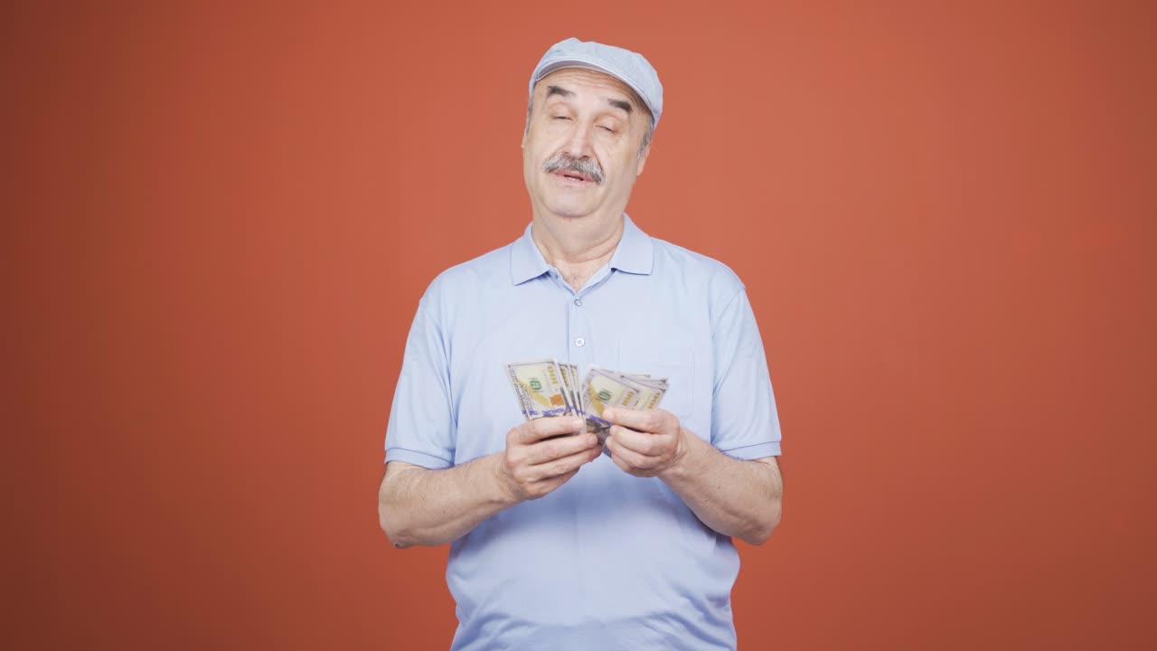 카메라를 쳐다보며 돈을 세는 노인.