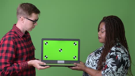 overweight african woman and young scandinavian man together against green background