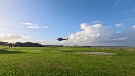 helicopter descends onto a grassy field