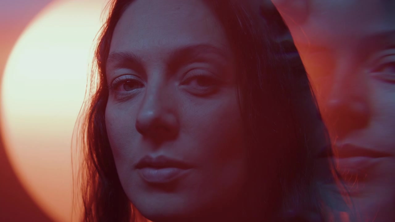 Ritratto caleidoscopico di donna in un caldo bagliore arancione e luci bokeh