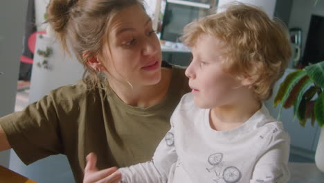 woman and little son playing on digital tablet at home
