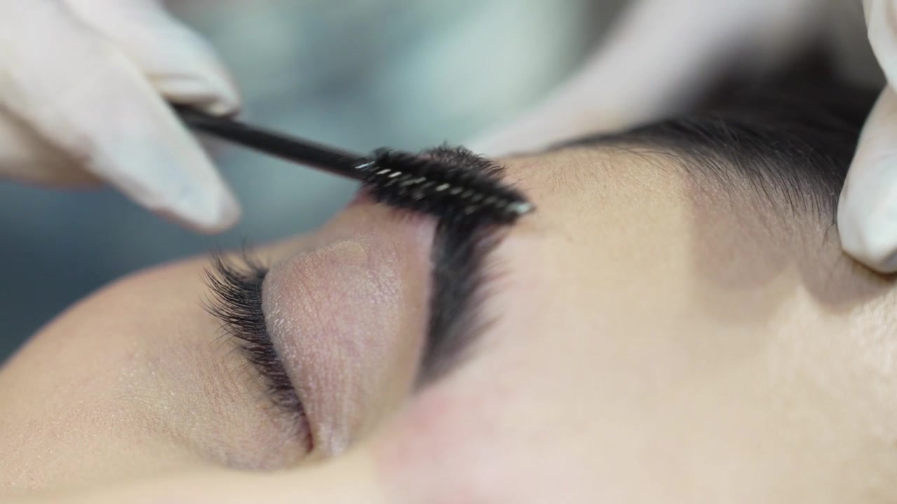 Closeup Shot of a Woman’s Eyebrow Being Brushed After Microblading or Lamination Procedure