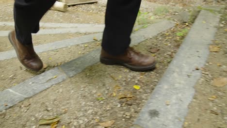 primer plano de grandes zapatos de hombre caminando por un sendero en el bosque