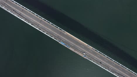 top down view as cars drive across ocean road suspension bridge