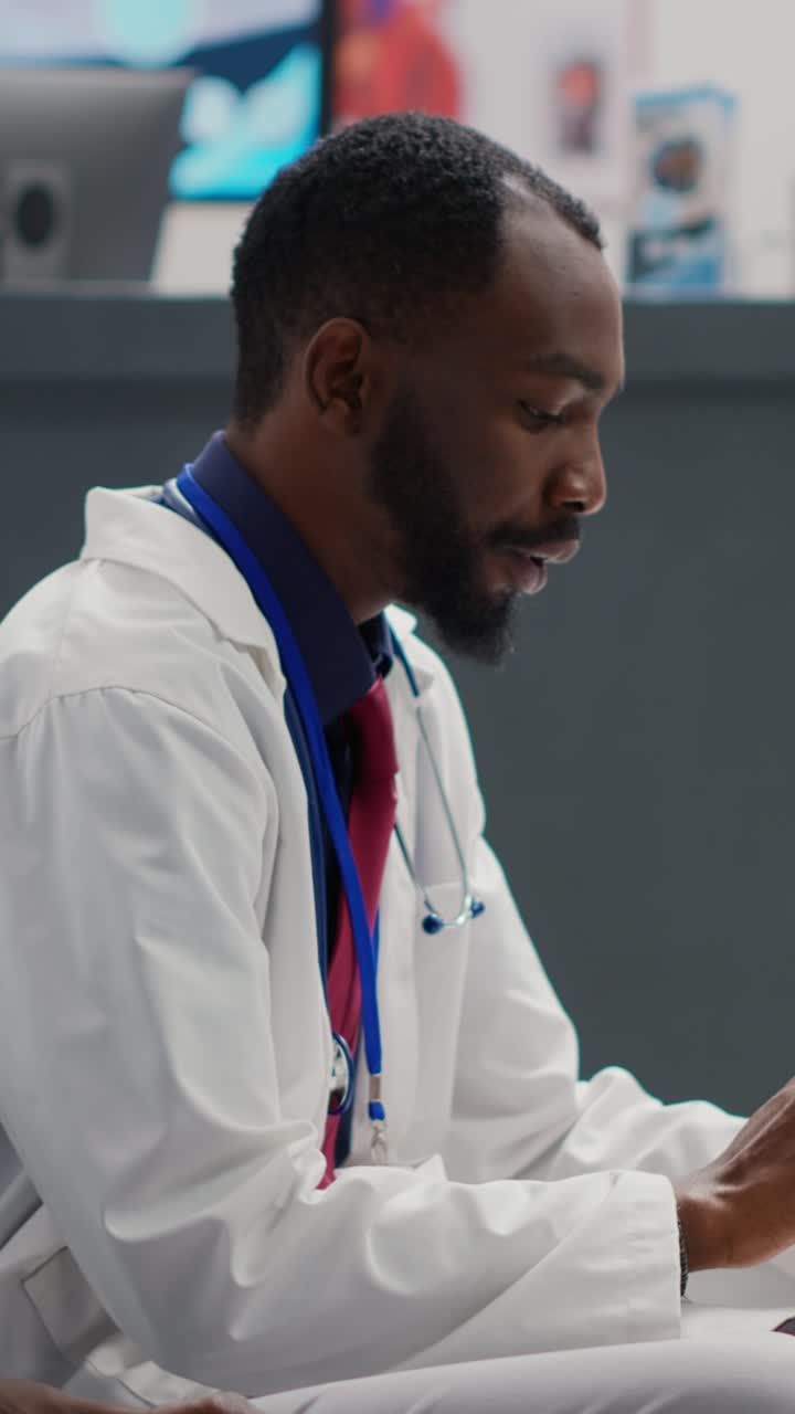 Vertical video: Professional medic showing diagnosis on digital tablet to male patient
