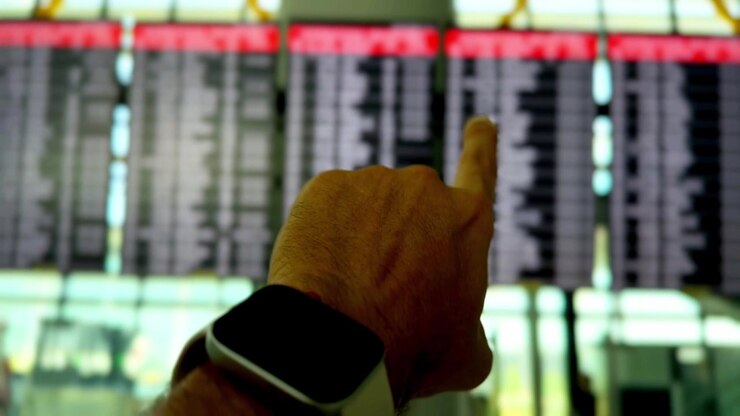 Traveler Pointing at Flight Schedule Display Board at Istanbul Airport Terminal