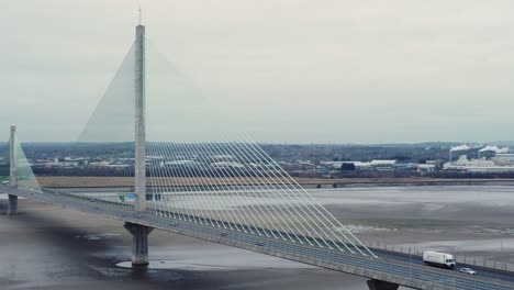 aerial view mersey gateway cable stayed toll bridge traffic crossing river mersey at low tide