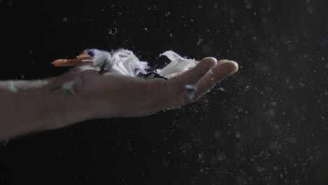 Closeup-Of-A-Hand-Catching-Recycled-Textiles-During-Manufacturing,-Fibers-And-Thread-Floating