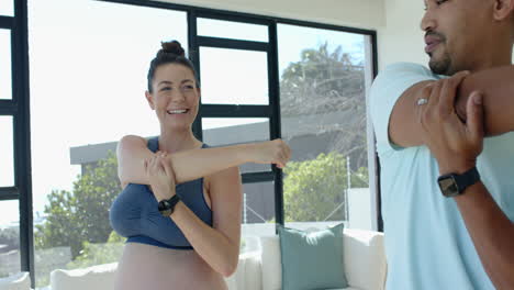 stretching together, pregnant woman and man exercising in living room