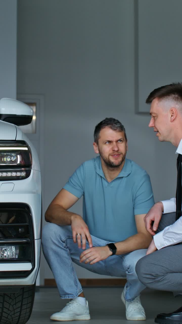 cliente y vendedor inspeccionando un coche nuevo