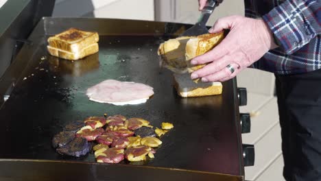 Making-Texas-toast-breakfast-sandwiches-on-the-flat-top-griddle-outside---isolated-slow-motion-close-up