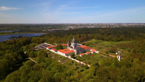 Drone-shot-of-old-Pazaislis-Monastery-and-Church-on-sunny-day-with-blue-clear-sky,-in-Kaunas,-Lithuania,-parallax-shot