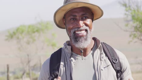 un anciano afroamericano pasa el tiempo en una cabaña de madera y hace senderismo.