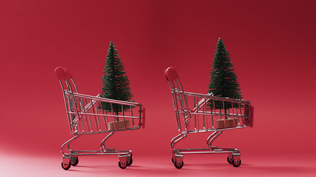 video de un carrito de compras con árboles de navidad y espacio de copia en fondo rojo