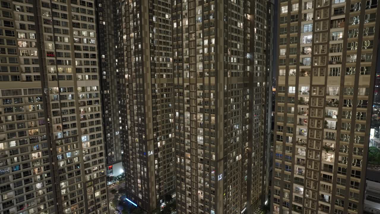 Statisch beeld van geclusterde hoge woongebouwen met verlichte ramen 's nachts in Ho Chi Minhstad Vietnam.