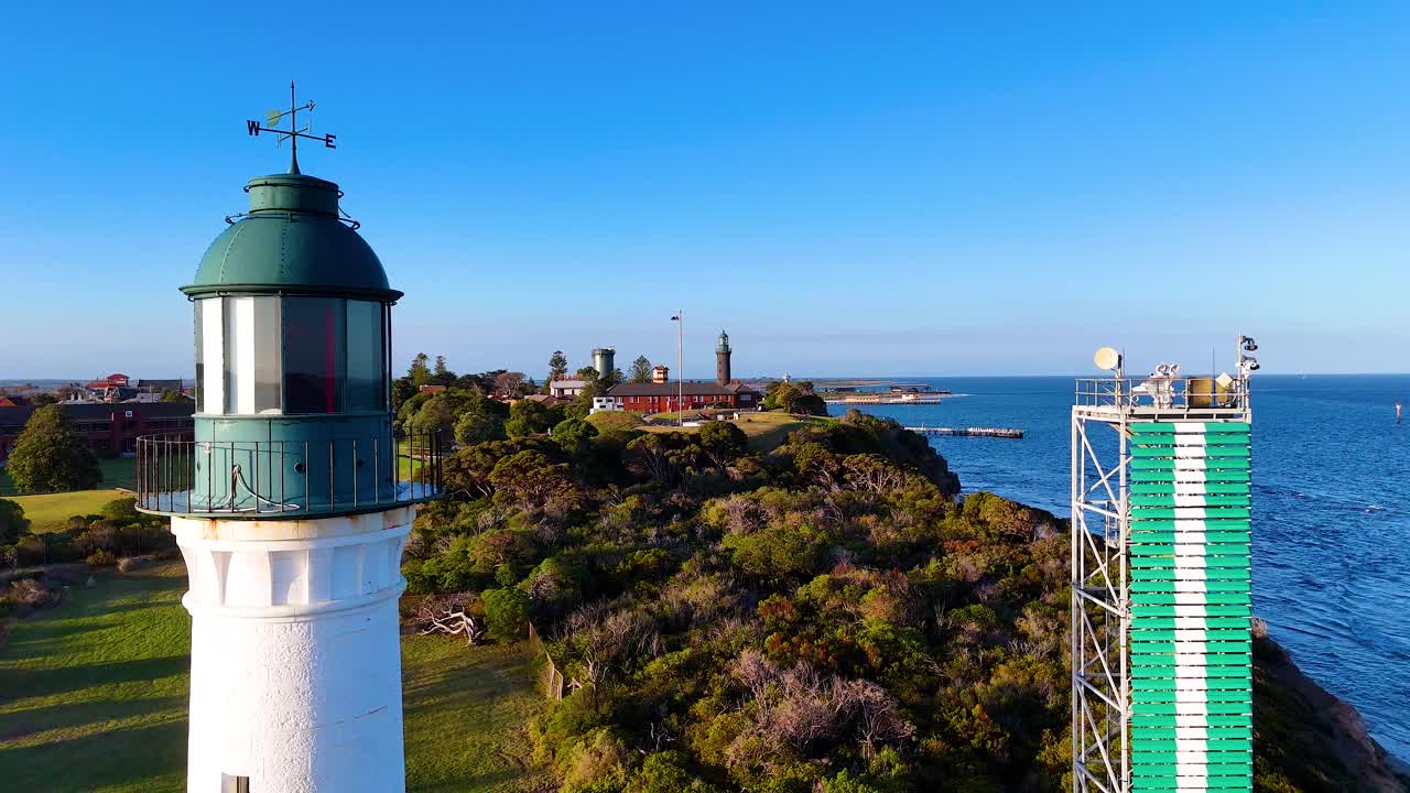 Aerial footage captures the picturesque Queenscliff Lighthouse and surrounding coastal landscape in Bellarine, Victoria, under clear blue skies