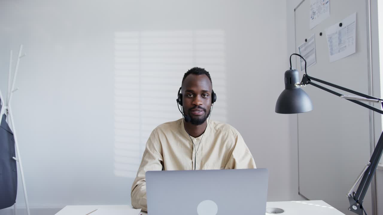 Man working from home on laptop wearing headset