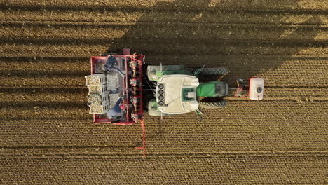 People-seeding-from-a-driving-tractor-on-a-farm-field