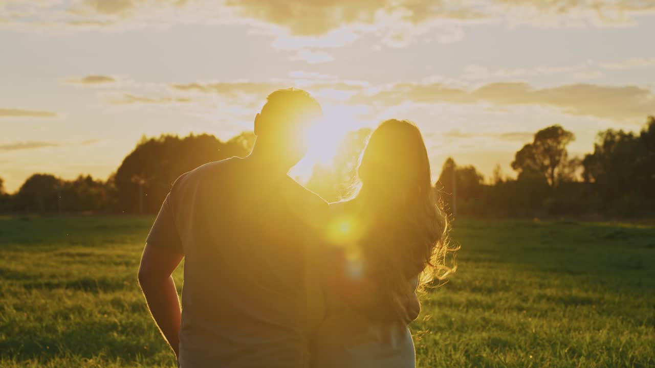 Couple watching sunset in a field