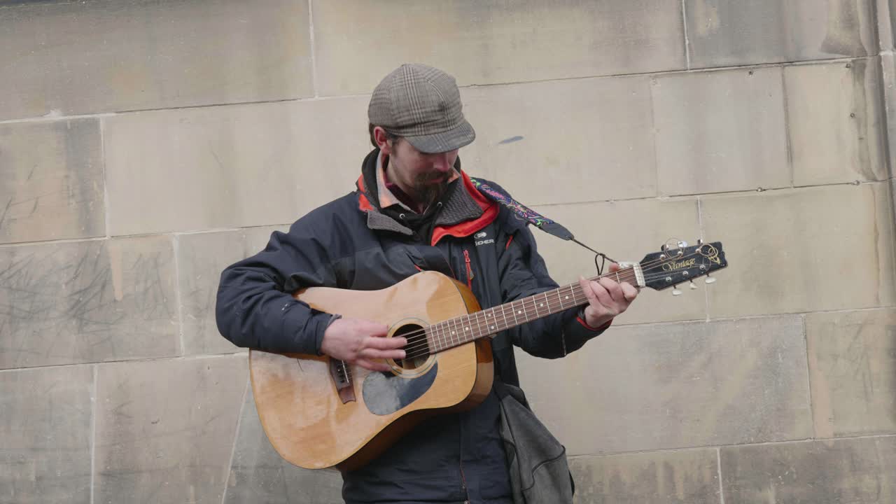 un músico callejero tocando su guitarra en las calles para ganar dinero