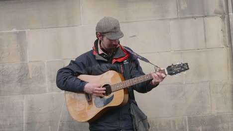 Un-Músico-Callejero-Tocando-Su-Guitarra-En-Las-Calles-Para-Ganar-Dinero