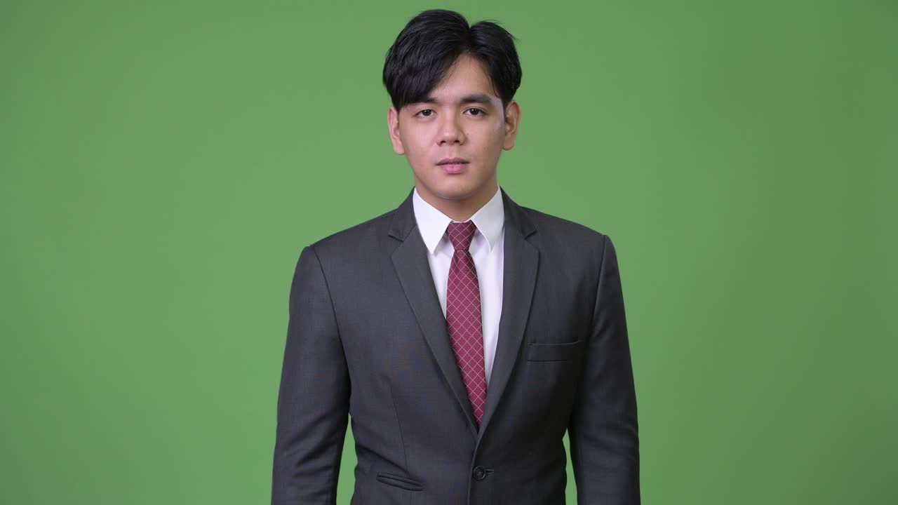 젊은 잘생긴 아시아 사업가가가 충격을 받았습니다.