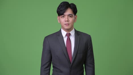 joven y guapo hombre de negocios asiático que parece conmocionado