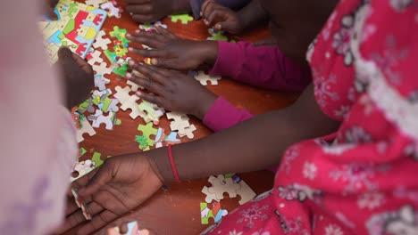 niños africanos haciendo un rompecabezas y jugando en el orfanato