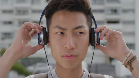 close up portrait cute young asian man student puts on headphones listening to music enjoying relaxed summer vacation leisure lifestyle entertainment slow motion