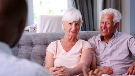 happy senior couple taking financial advice at home