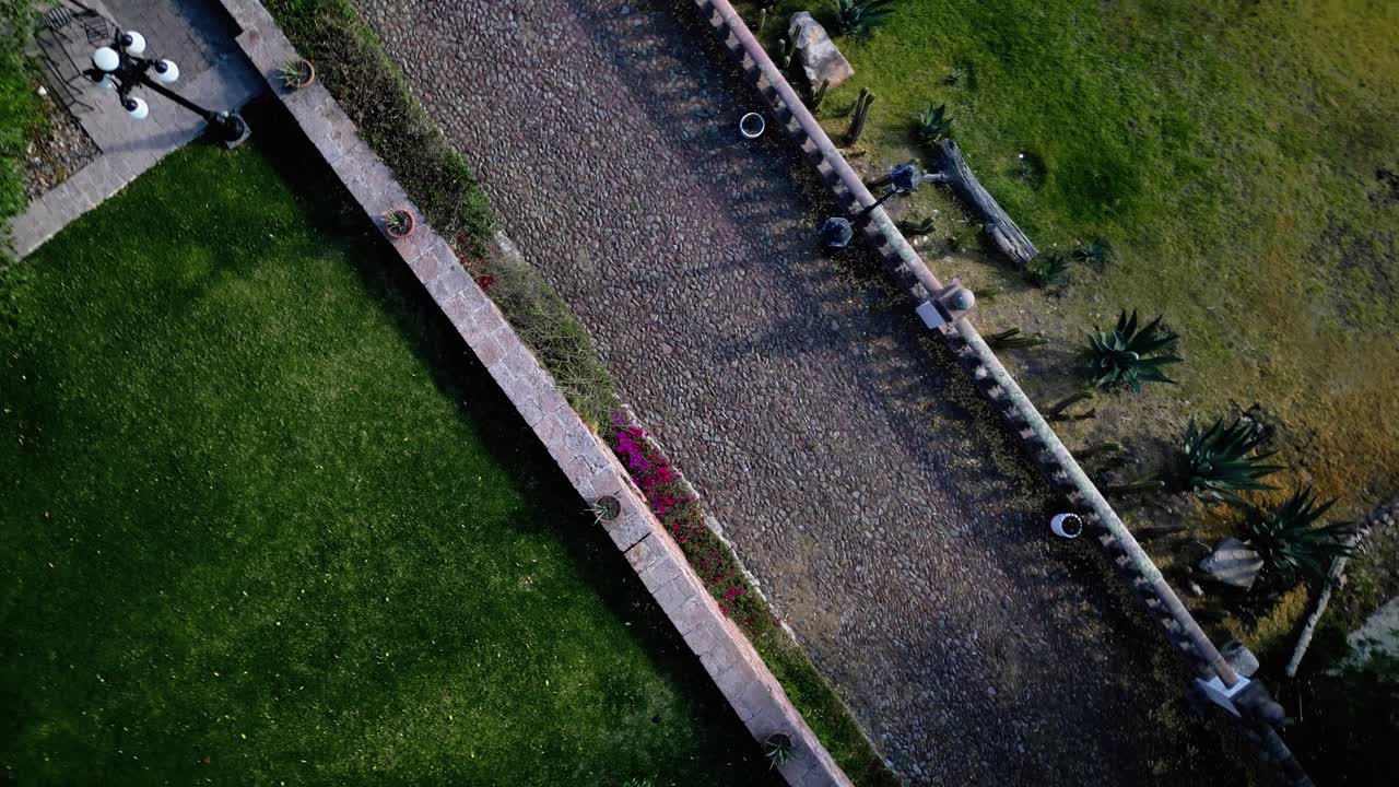 Rocky path through grass, spiral aerial shot.