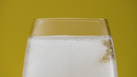 water gets carbonated after dropping fizzy vitamin tablet in glass, isolated