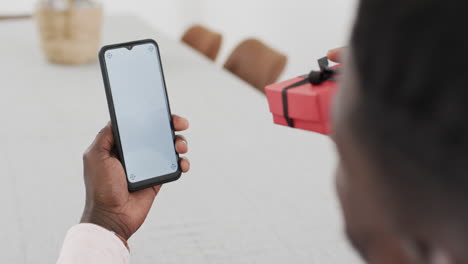 African-American-man-holding-a-smartphone-on-a-video-call,-with-copy-space