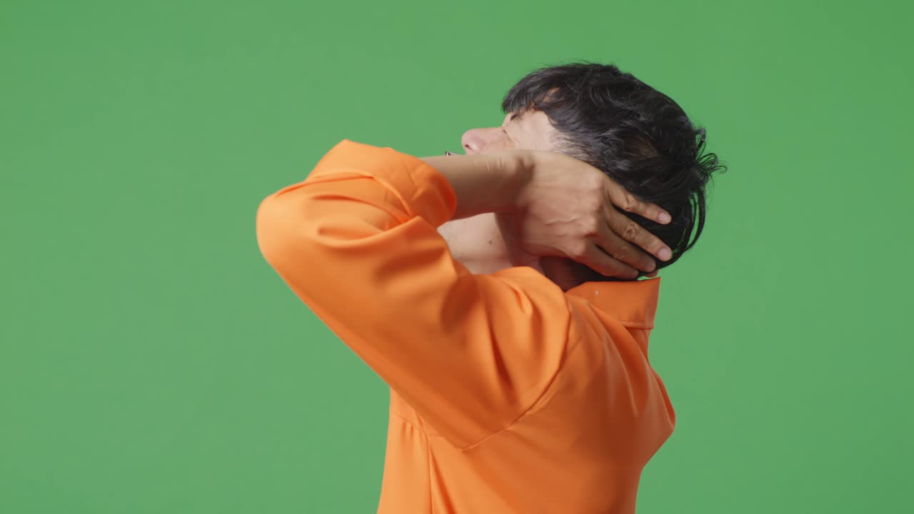 녹색 스크린에 오렌지색 스웨터를 입은 남자