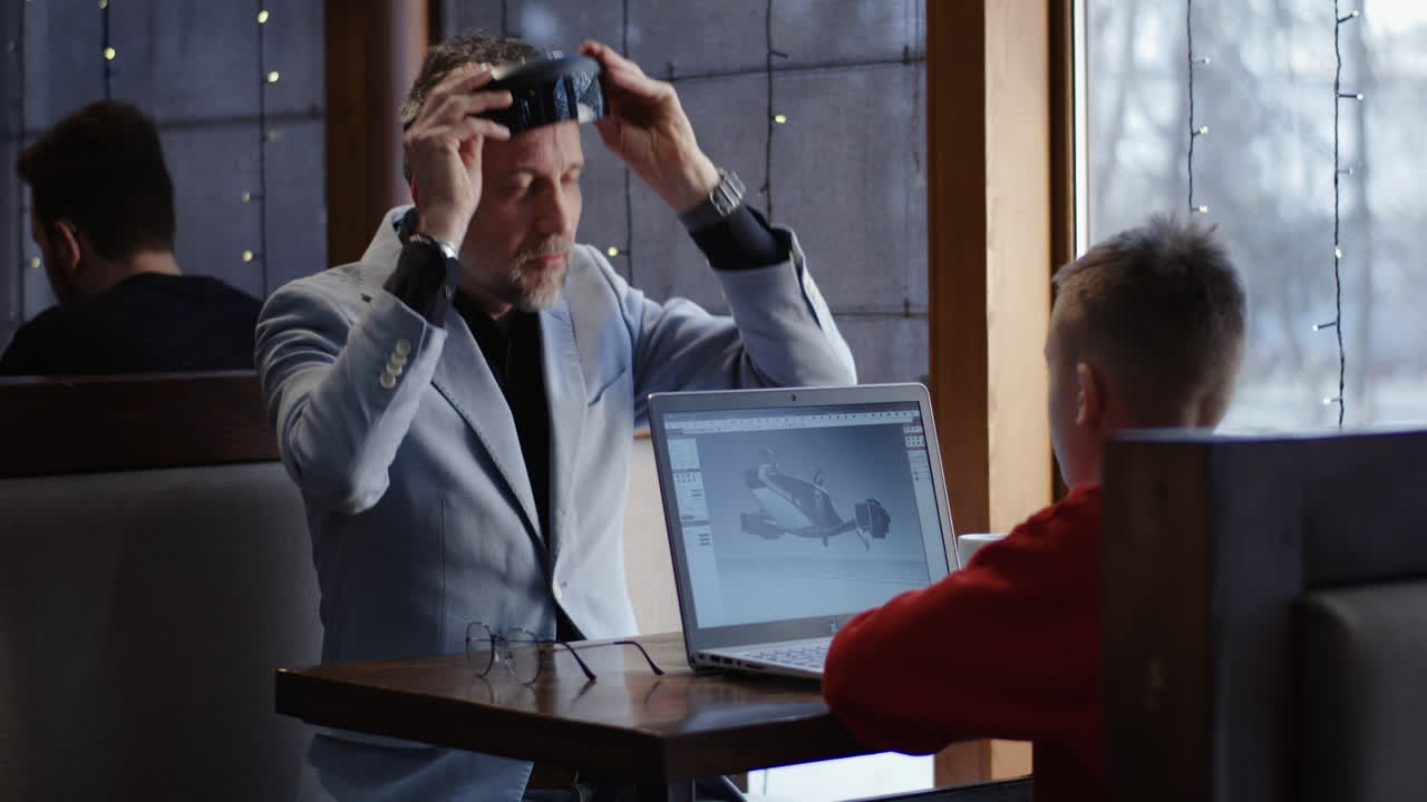 Adult and Child Collaborating on 3D Design Project in Cafe