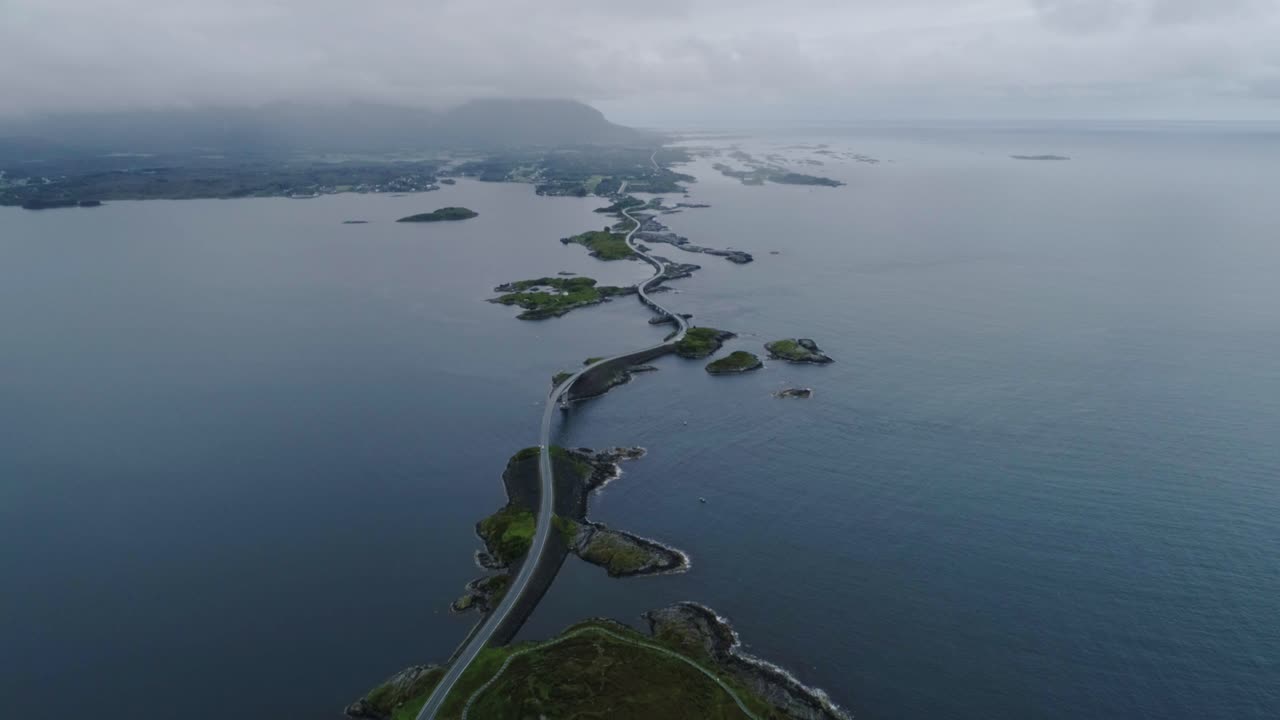 Drone of overcast Norway’s Atlantic Road weaving across islets in calm blue sea