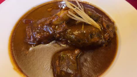 featuring of mutton roganjosh dish with thick gravy served in a bengali restaurant.