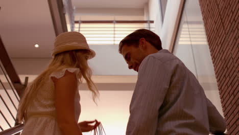 pareja montando la escalera mecánica en el centro comercial