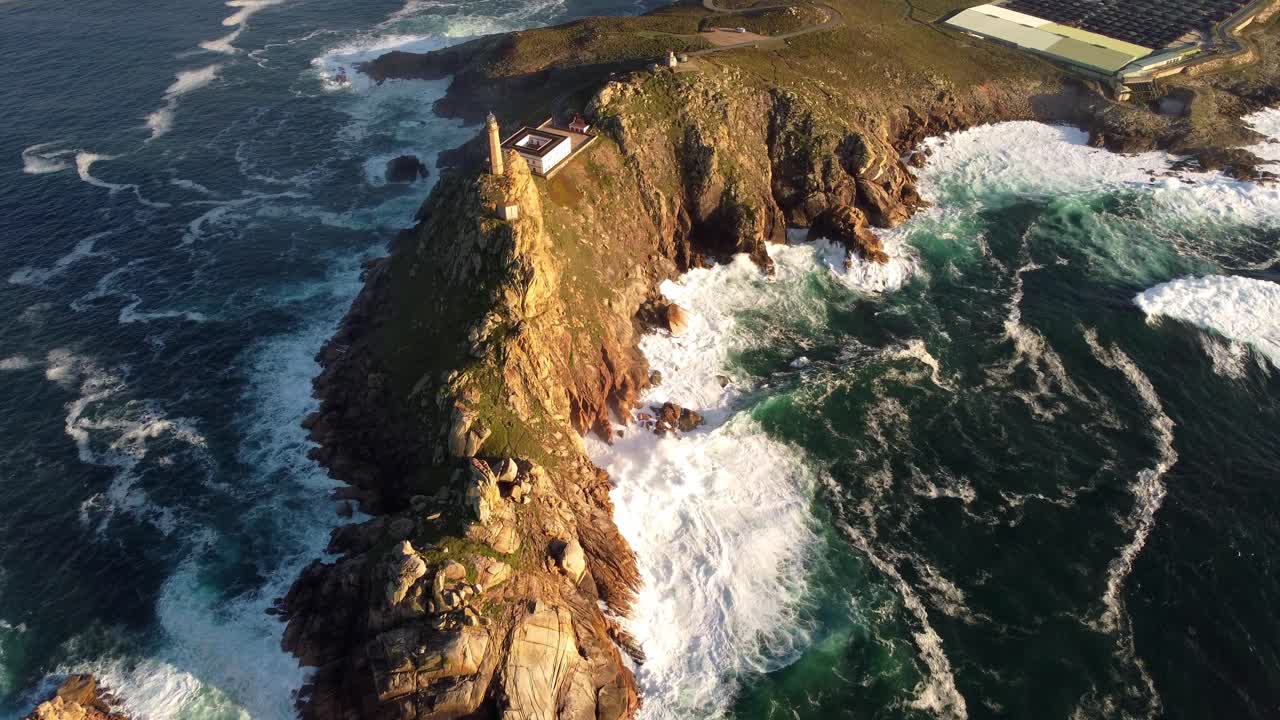 Drone footage sunset on lighthouse top of cliff rock formation Atlantic Ocean seascape coastline of Galicia region Cabo vilan north Spain tourist destination