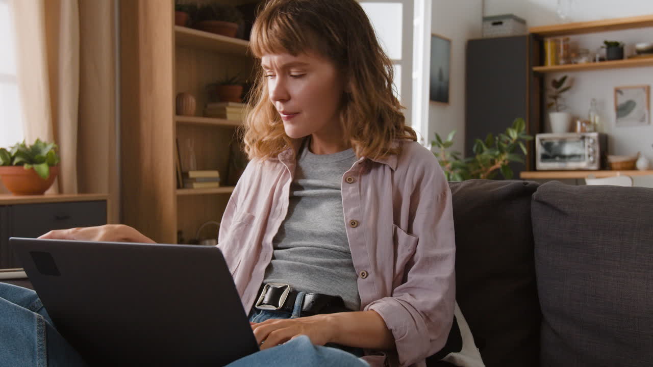mujer usando computadora portátil y teléfono inteligente en casa